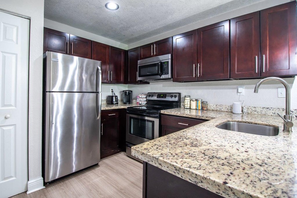 a kitchen with stainless steel appliances and granite counter tops