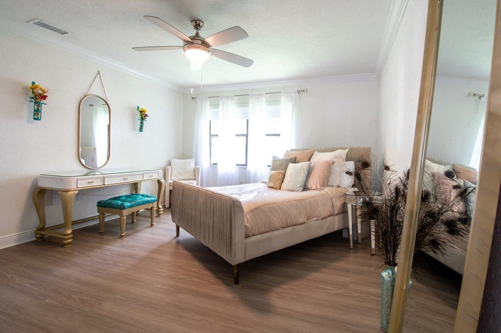 a bedroom with a bed and a ceiling fan