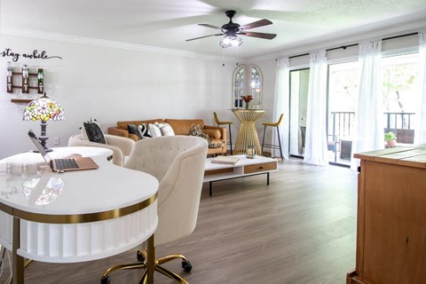 a living room with a couch and a table and a ceiling fan