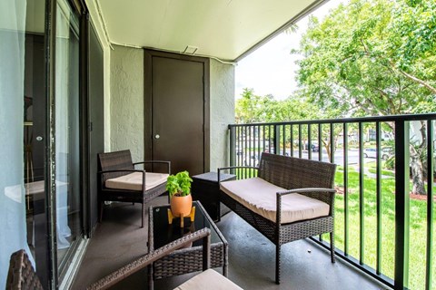 a balcony with wicker chairs and a table