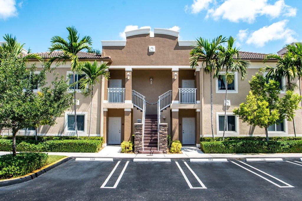 a building with stairs and palm trees in front of it