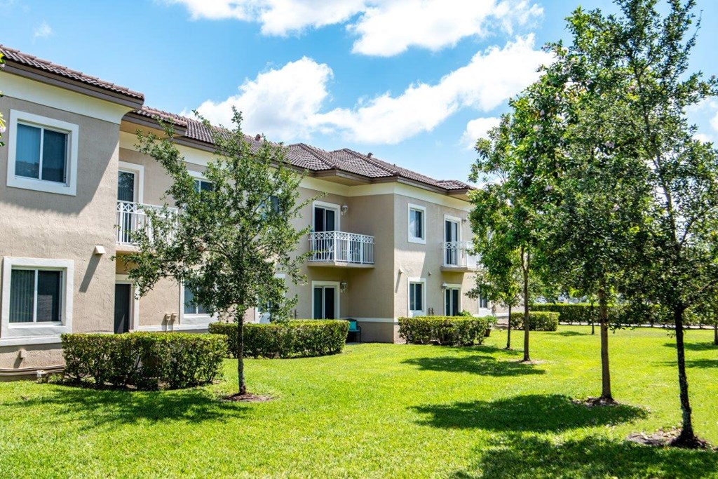a house with a lawn and trees in front of it