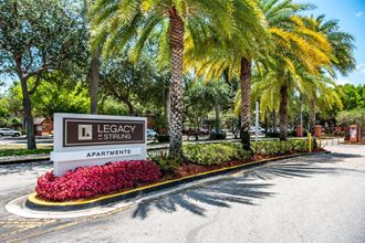 a sign for legacy springs apartments in front of palm trees