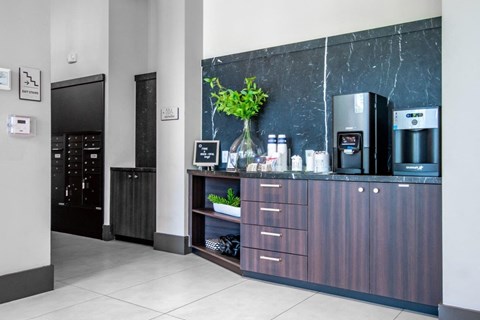 a lobby with a coffee machine and a wooden cabinet