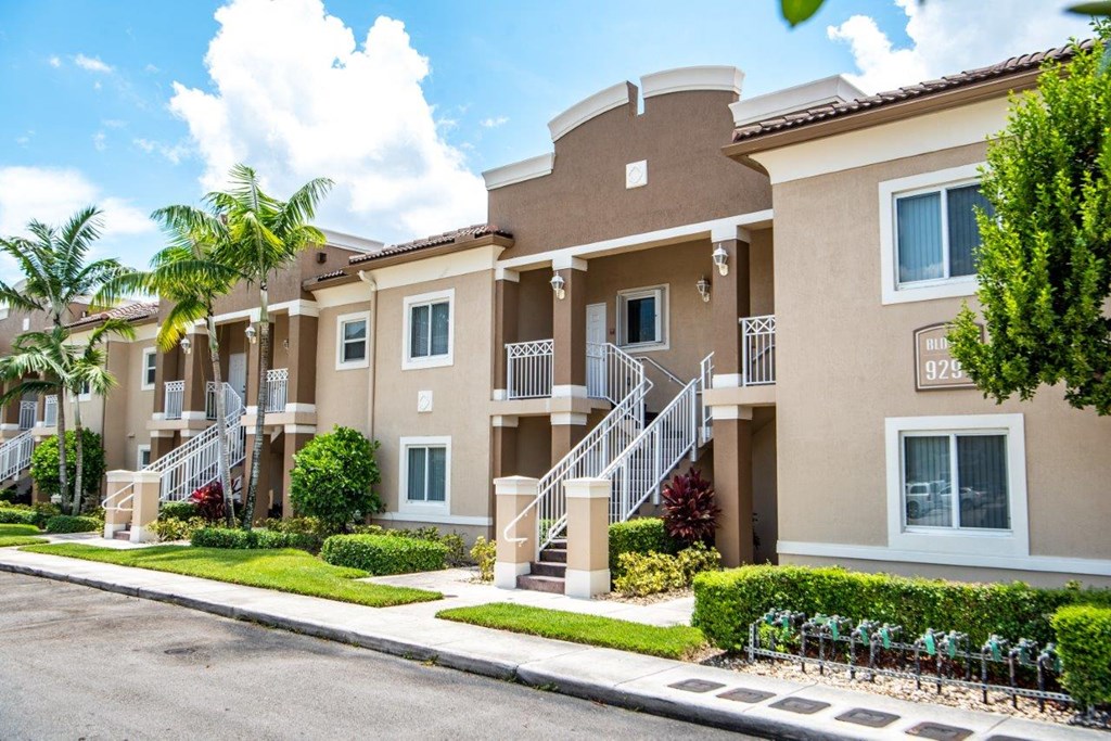 a street view of an apartment building with stairs and balconies
