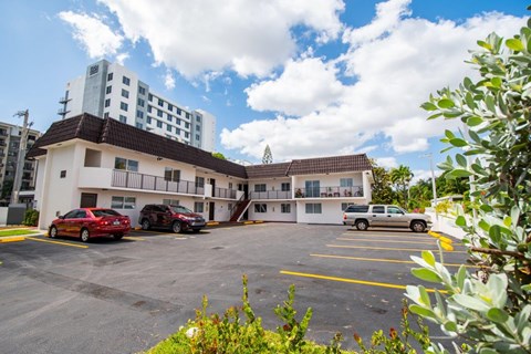 A parking lot with cars and a building in the background.