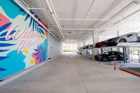 a parking garage with cars parked in it and a mural on the wall