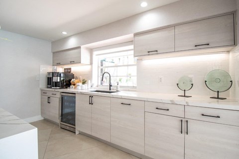 a kitchen with white cabinets and a window