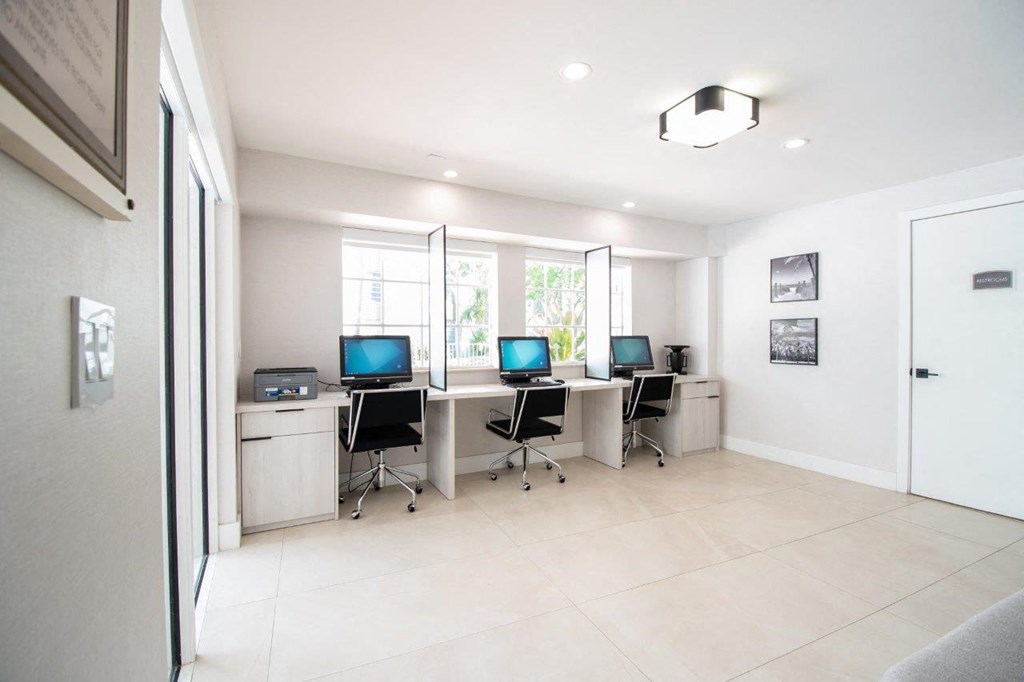 a room with three computers on a table