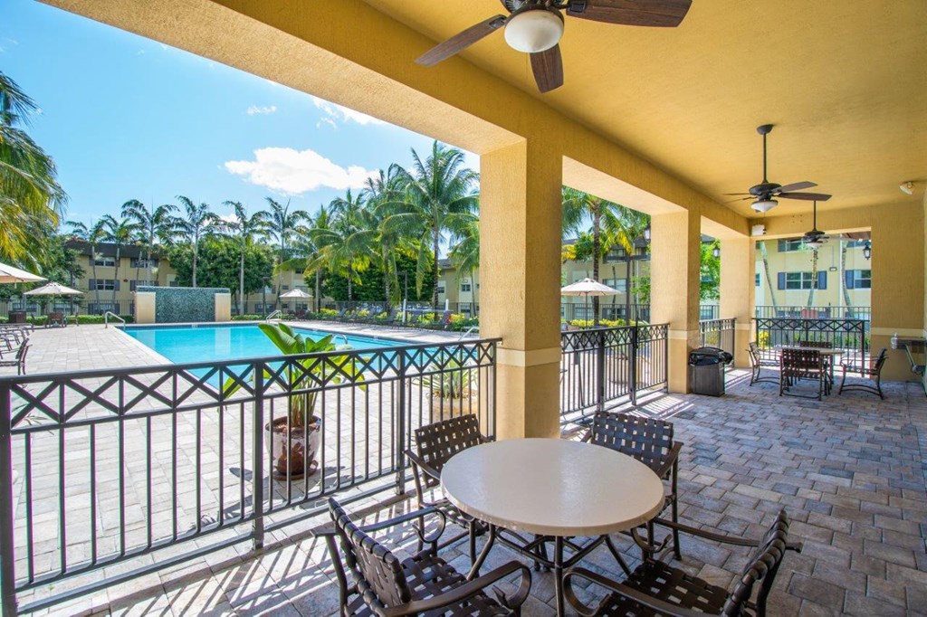 a patio with a table and chairs next to a swimming pool