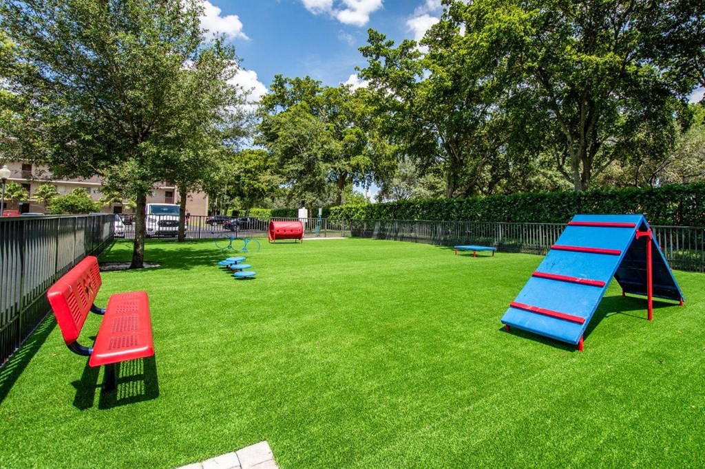 a play yard with a slide and chairs on the grass