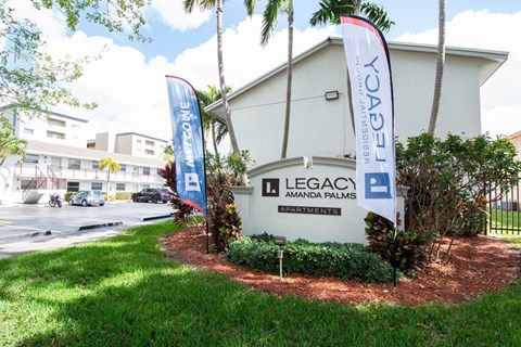 A white building with a sign that says Legacy Amanda Palms.