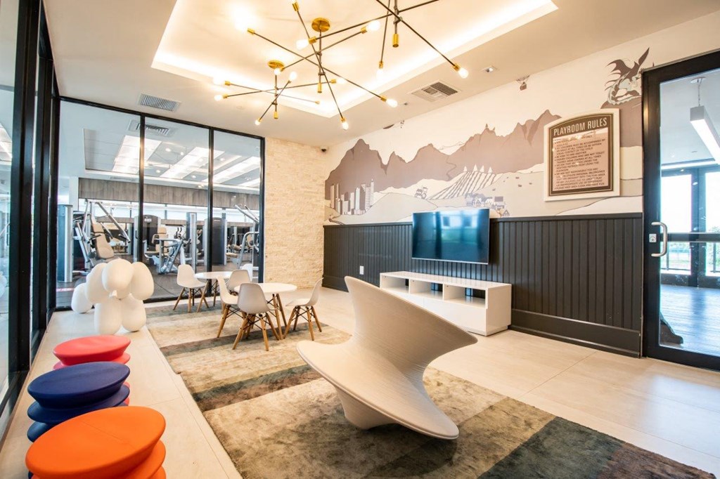 a lounge area with a tv and chairs in a lobby