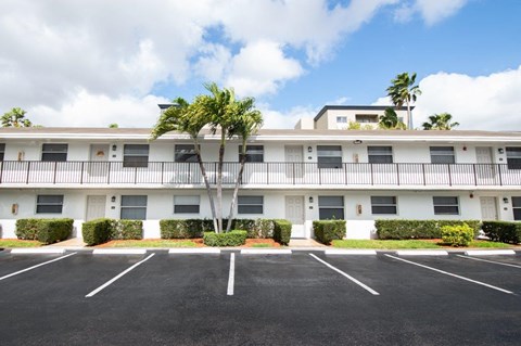 A large white building with a parking lot in front.