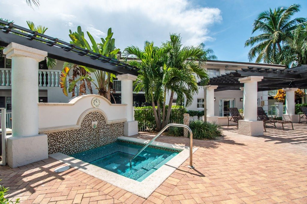 a small pool is in the middle of a house with palm trees