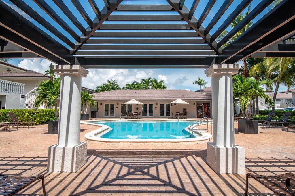 a large swimming pool with a house in the background