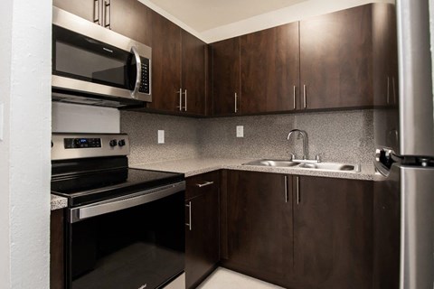 a kitchen with a sink and a stove and a microwave