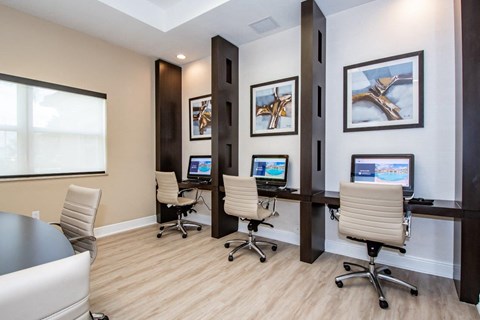 a conference room with three desks and chairs and a window