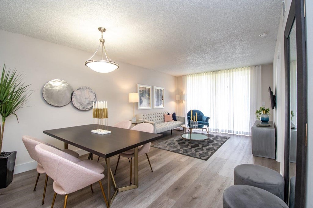 a living room and dining room with a table and chairs