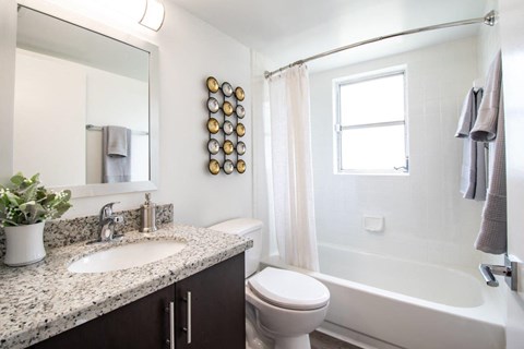 A bathroom with a white tub, sink, and toilet.
