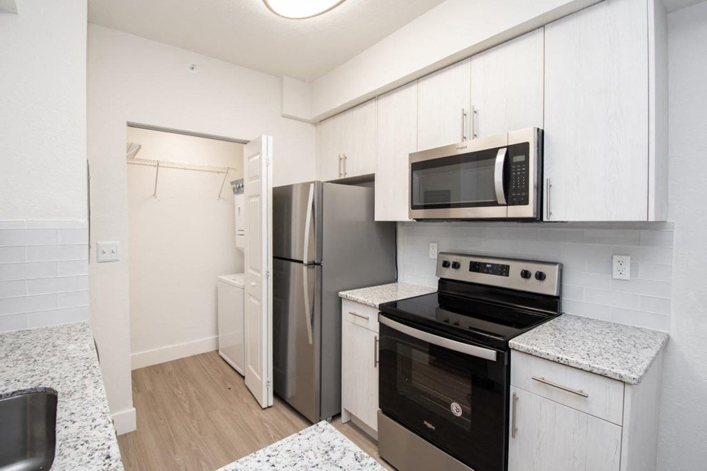 a kitchen with stainless steel appliances and white cabinets