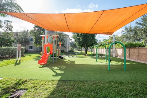a playground with a shade canopy over it