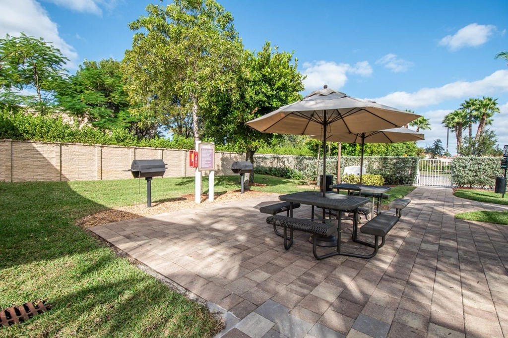 a patio with a picnic table and an umbrella