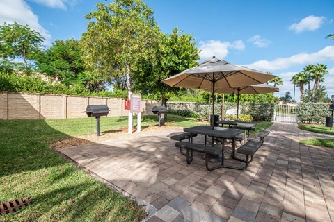 a patio with a picnic table and an umbrella
