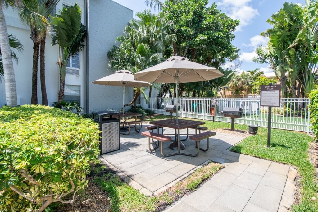 A patio with a table and chairs under an umbrella.