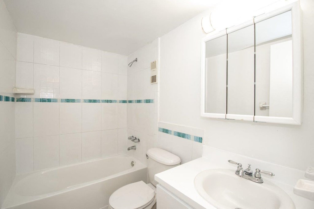 a white bathroom with a sink toilet and bath tub