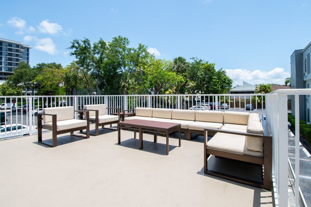 A patio with white railings and furniture.