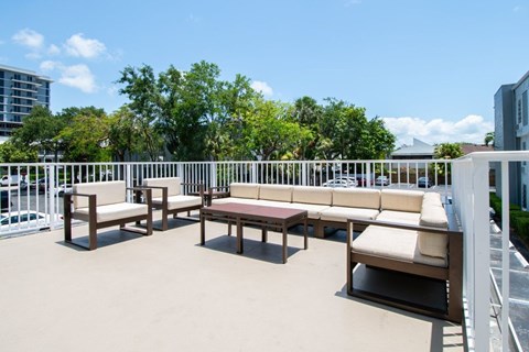 A patio with white railings and furniture.