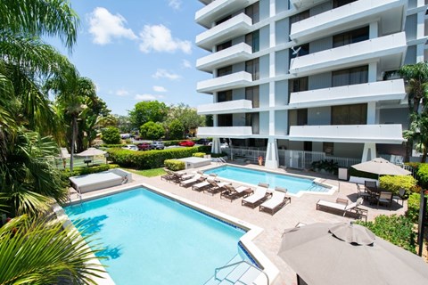 A large white building with a pool in front.