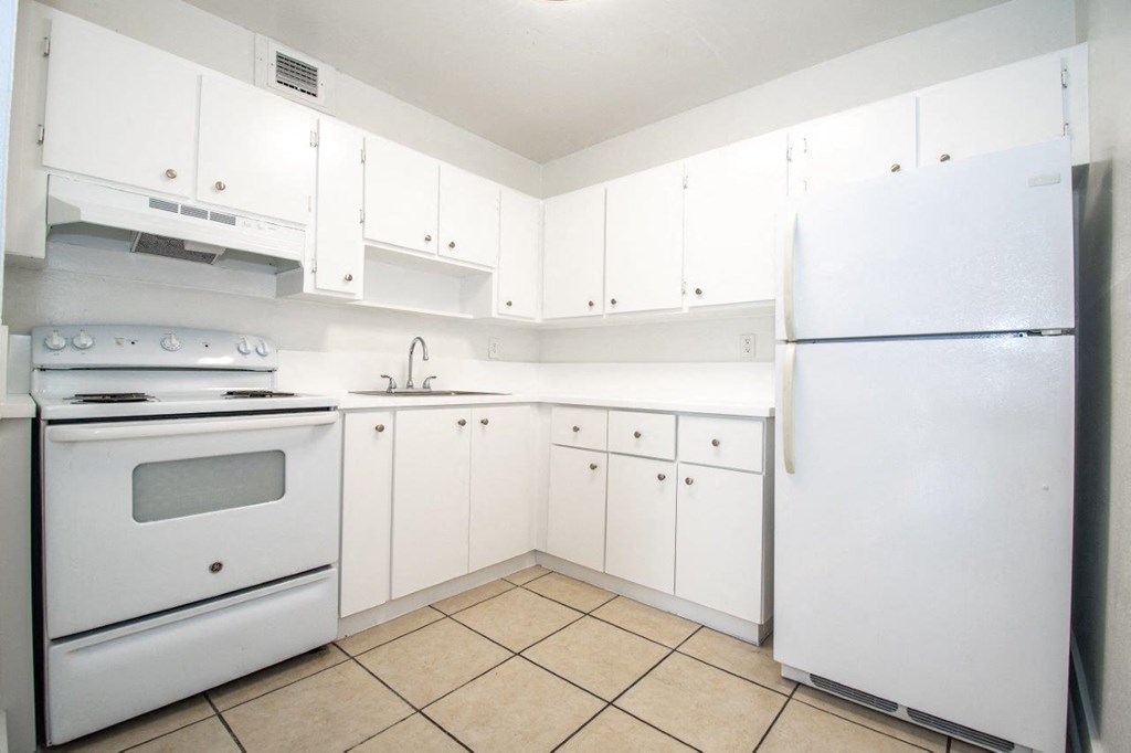 a white kitchen with white appliances and white cabinets