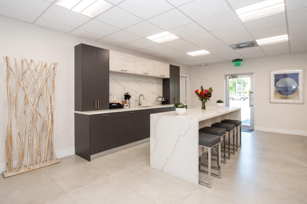 a kitchen with a marble counter and a bar with stools