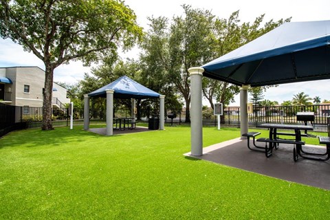 a picnic area with picnic tables and umbrellas