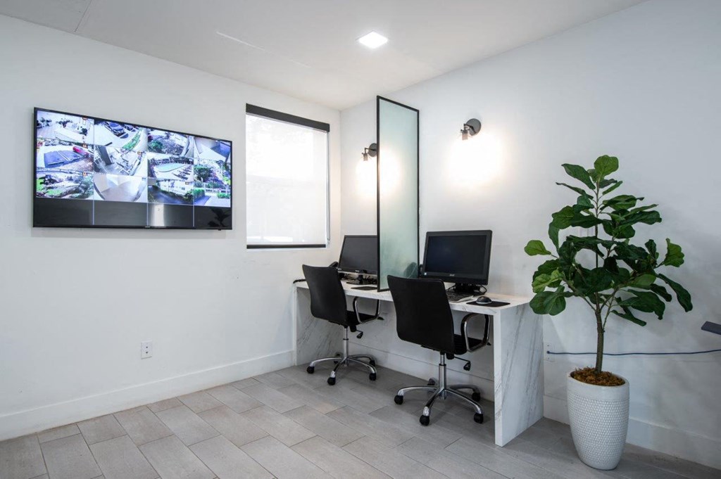two desks with two computers and a tv in a room