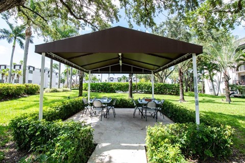 a covered patio with tables and chairs under a canopy