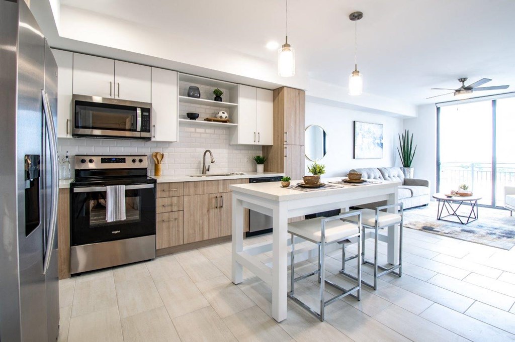 a large kitchen with a white island and stainless steel appliances