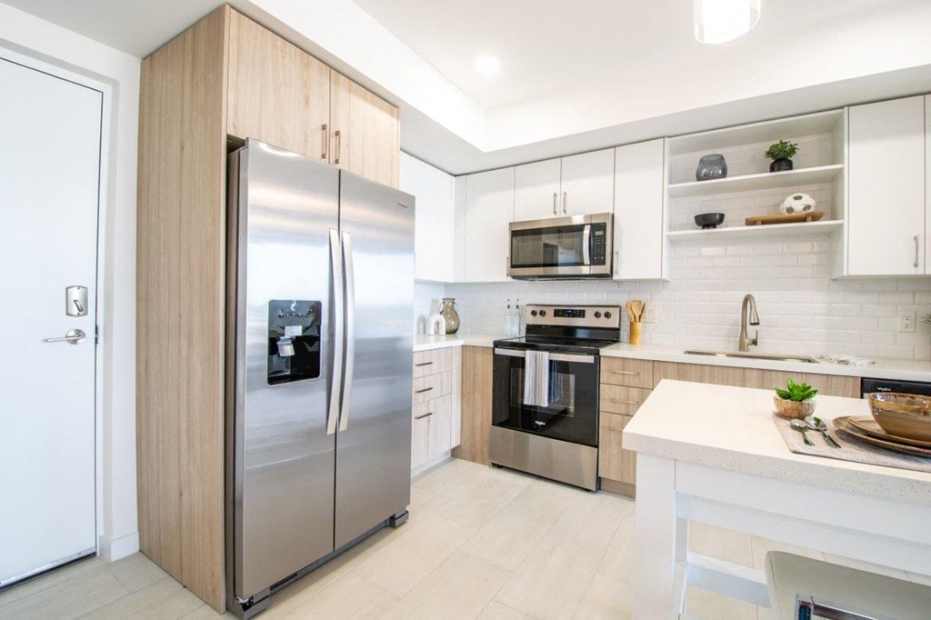 a modern kitchen with stainless steel appliances and white cabinets