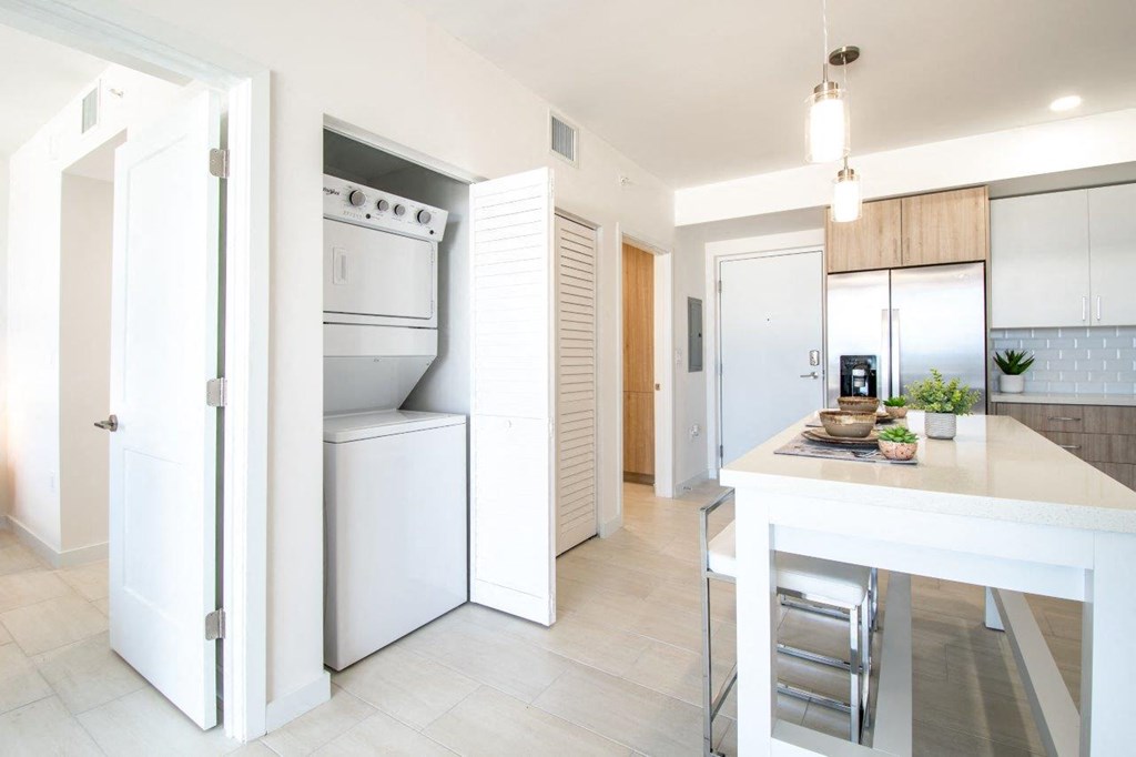 a white kitchen with a island and a refrigerator
