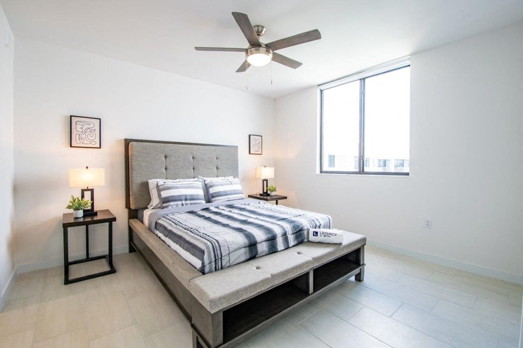 a bedroom with a bed and a ceiling fan