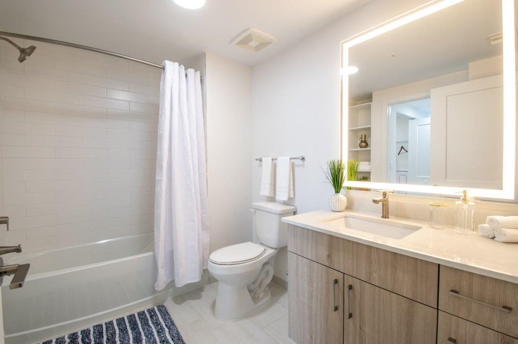 a white bathroom with a toilet and a shower