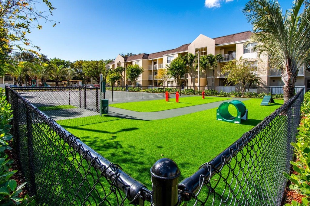 a park with a tennis court and a playground in front of a building