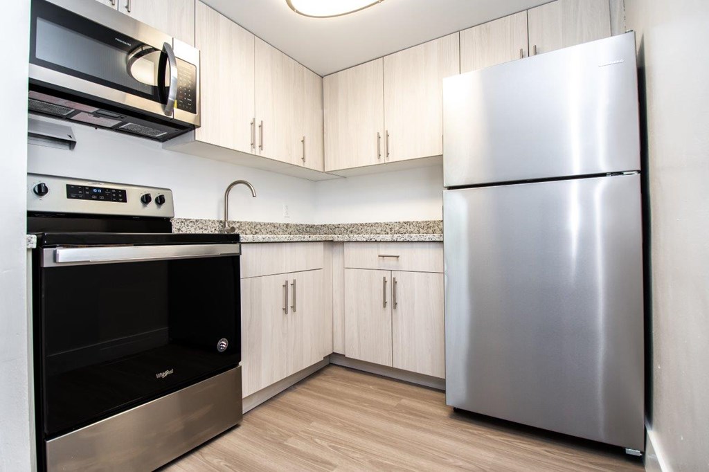A modern kitchen with a stainless steel refrigerator and oven.