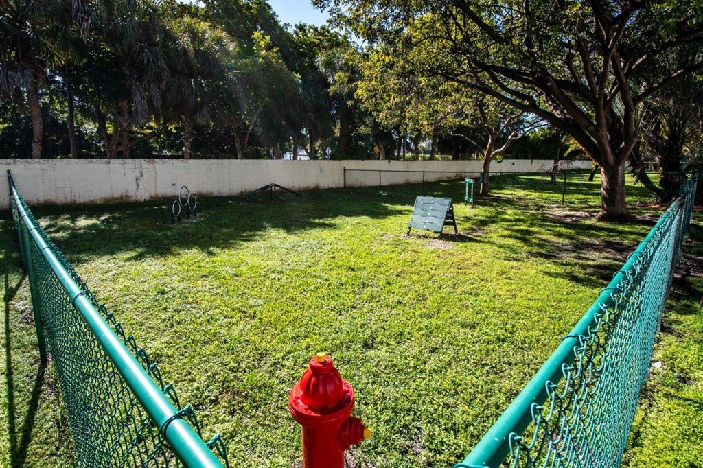 a red fire hydrant in the grass next to a fence