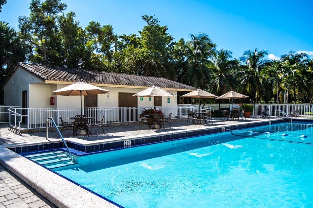 a swimming pool in front of a house with a resort style pool