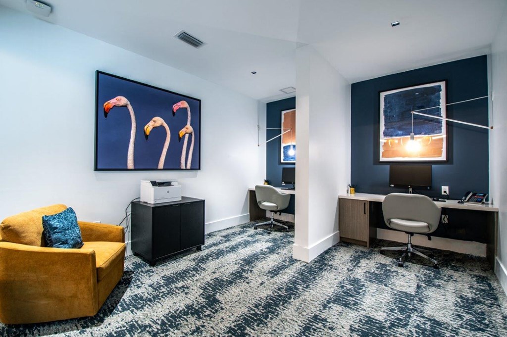 a conference room with a yellow couch and a desk with a computer