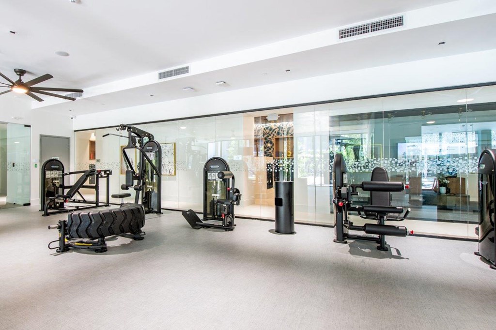 a gym with glass walls and equipment in it
