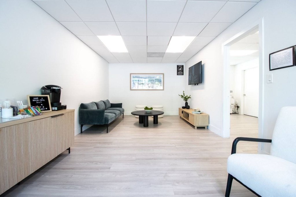 A waiting room with a couch, chair, and a coffee table.